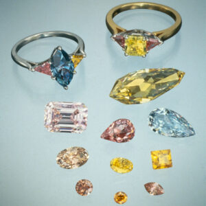 Two rings: (left) 1.86-ct. Fancy Deep blue diamond flanked by pink and yellow triangular cut diamonds, (right) 1.11-ct. Fancy intense yellow-green diamond flanked by 2 triangular cut orangy-pink diamonds. Photo courtesy of American Siba Corp, Moses Jewelers, Isaac Wold and Lazar Wolf.