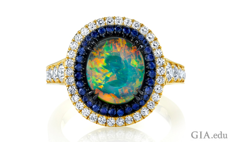 Black opal, sapphire and diamond ring set in 18k yellow gold with black rhodium