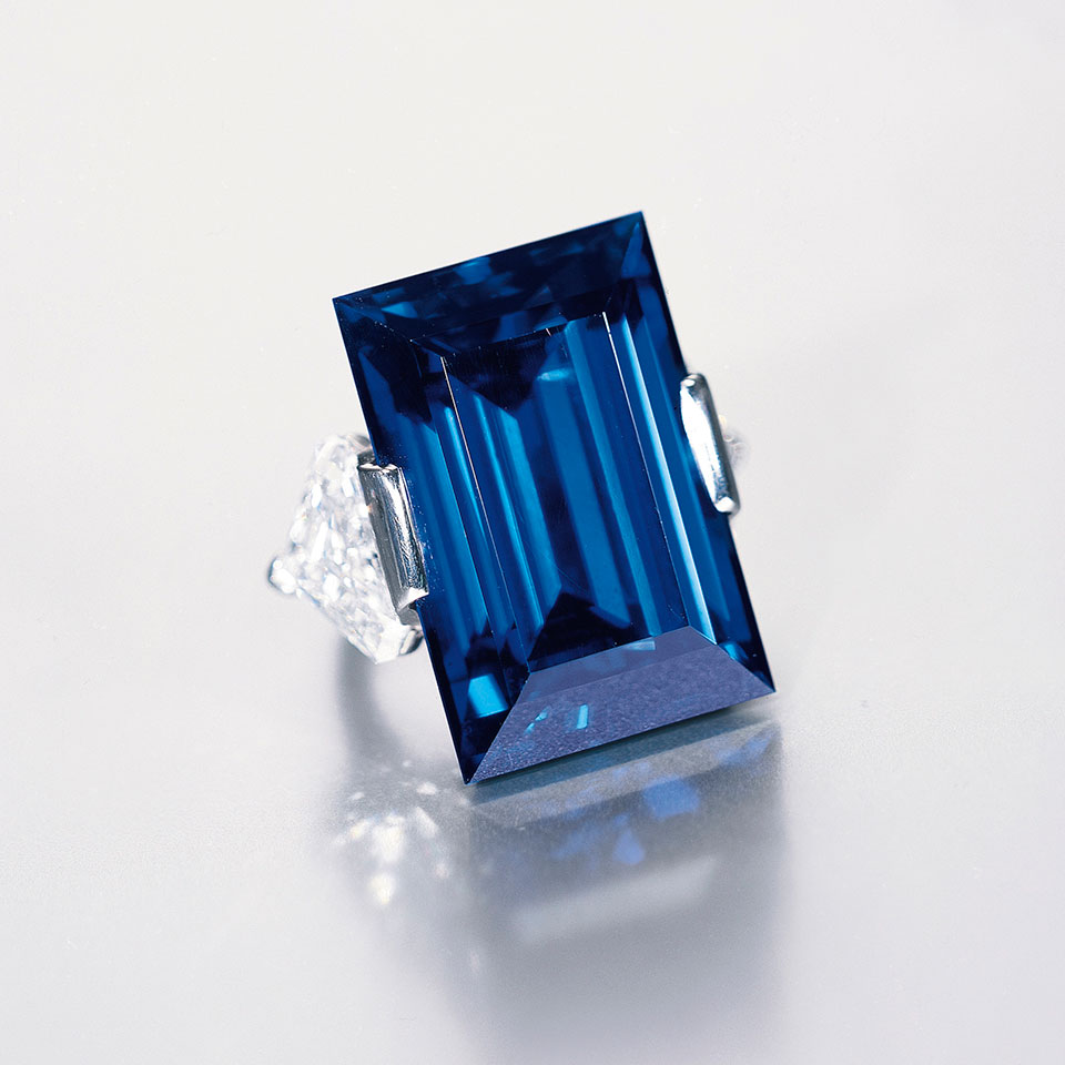 Rockefeller Sapphire weighing 62.02 ct, flanked by two triangular cut diamonds, mounted in a platinum ring signed Tiffany & Co.