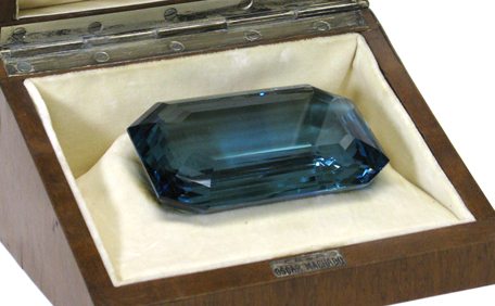 Aquamarine Gemstone: A large, rectangular-cut blue aquamarine gemstone in a display case.