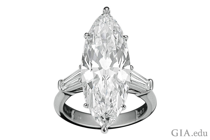 一颗颜色等级为 D 的 8.03 克拉马眼形切工钻石镶嵌于铂金订婚戒指之中，两侧各点缀着一颗梯钻，重 0.72 克拉。