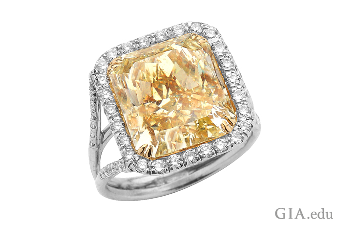 A 9.57 carat Fancy yellow radiant cut diamond engagement ring surrounded by 0.55 carats of round diamonds.