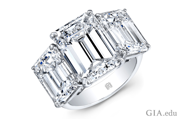 A modern diamond engagement ring featuring three emerald cut diamonds totaling 15 carats set in platinum. 