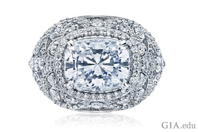 A rectangular shaped cushion cut diamond engagement ring featuring a cluster of diamonds and milgrain detail.