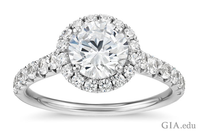 A 1.00 carat round brilliant cut diamond engagement ring accented by 0.50 carats of melee set in the halo and shank.