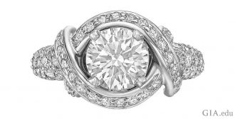 A 1.36 carat round brilliant cut diamond with twisting bands of platinum and 0.96 carats of melee.