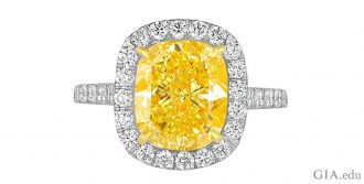 A 4.76 ct Fancy Vivid yellow diamond engagement ring with a halo of colorless diamonds.