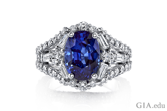 Blue oval sapphire ring with diamonds set in 18K white gold.