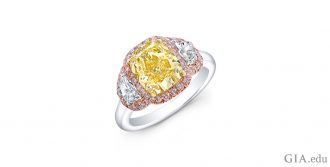 A 3.03 ct fancy yellow cushion cut diamond with 0.54 carats of half-moon cut diamonds set in platinum, yellow gold and rose gold.