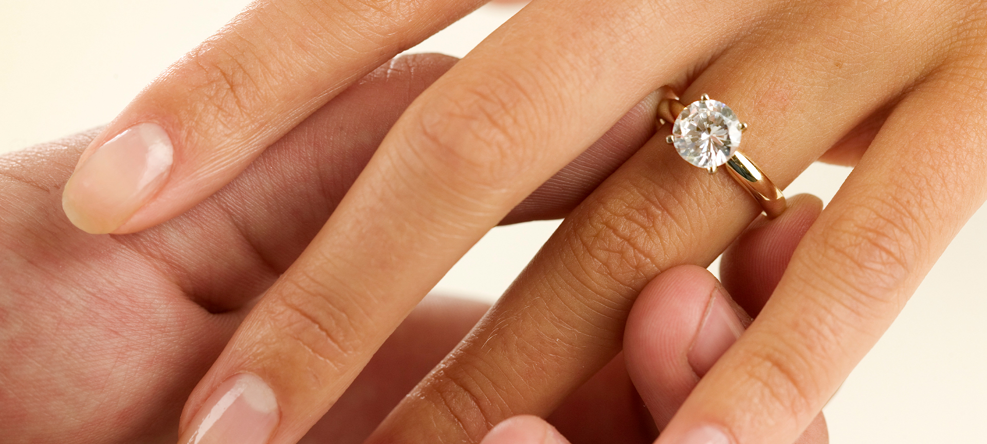 A woman’s hand wearing a diamond engagement ring.