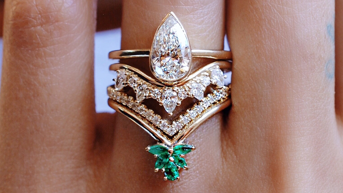 Diamond engagement ring with two diamond and emerald bands.