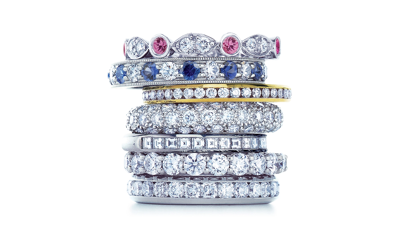 A stack of diamond and colored stone eternity bands.