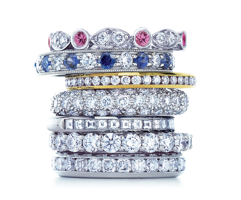 A stack of diamond and colored stone eternity bands