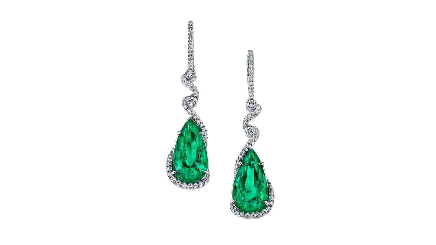 Emerald drop earrings accented by diamonds.