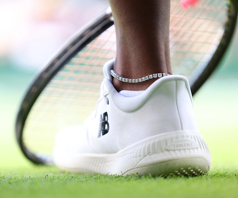 Close-up of tennis player Sloane Stephen’s diamond tennis anklet with her racket in the background