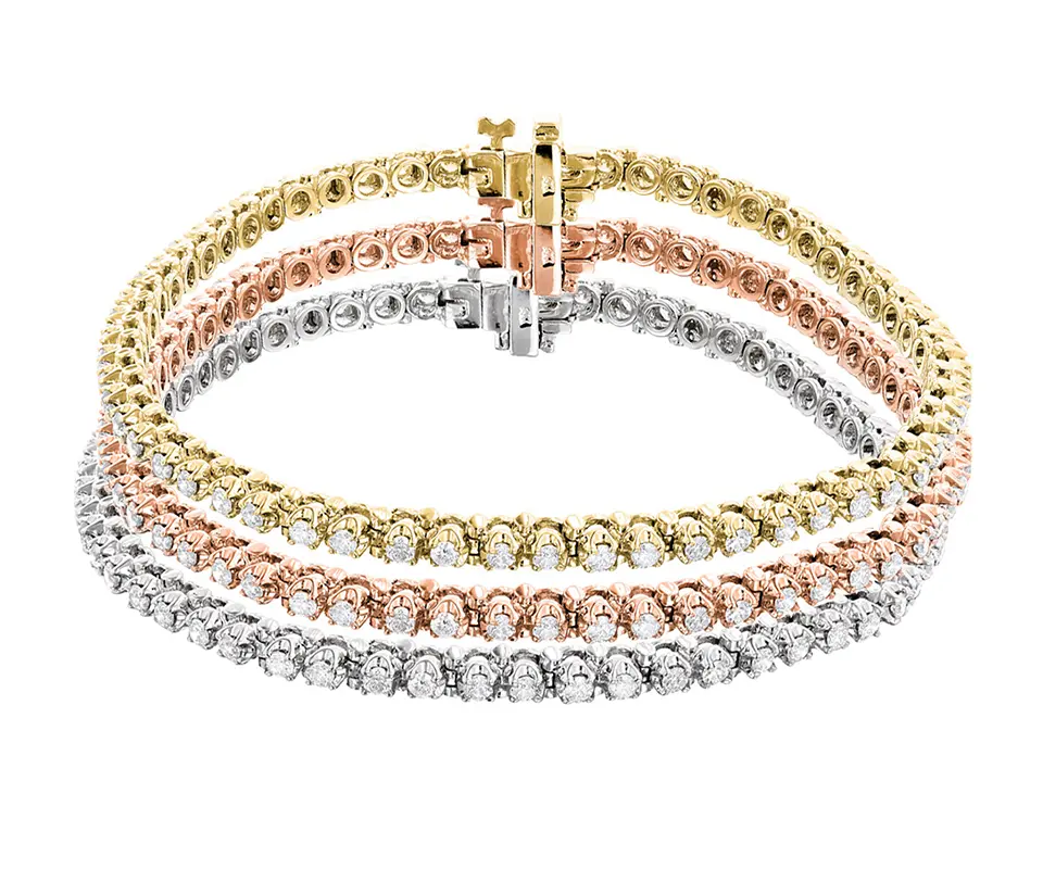 Three diamond tennis bracelets in white gold, rose gold and yellow gold stacked on top of each other