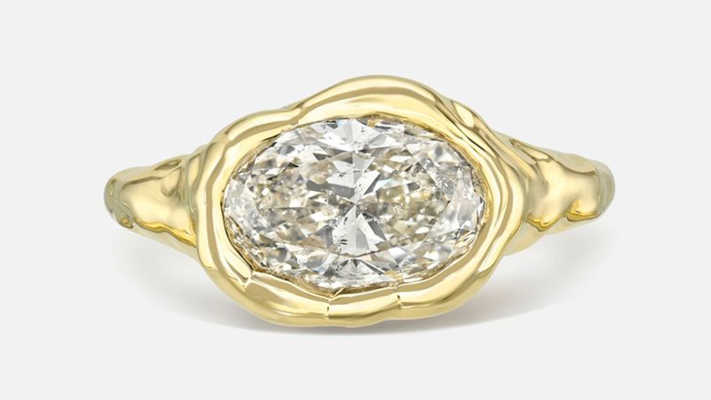 An east-west, bezel set solitaire ring with an oval diamond center stone
