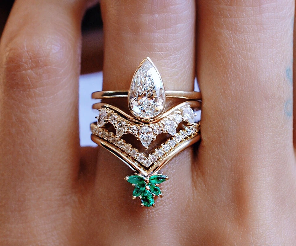 Woman’s hand with a diamond engagement ring and two stacked wedding bands