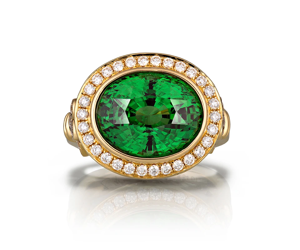 Oval tsavorite garnet ring in yellow gold on white background
