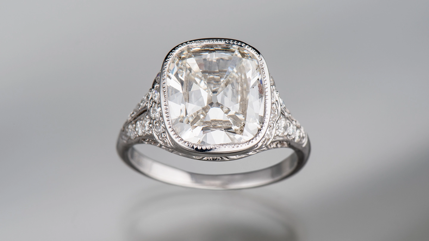 Old mine cut diamond ring on gray background.
