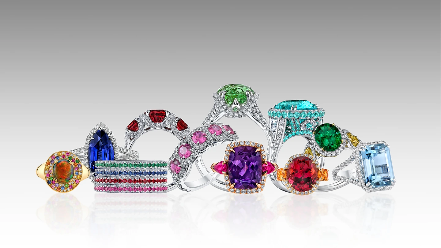 Variety of colored gemstone rings artfully positioned against gray background, great alternatives for engagement rings