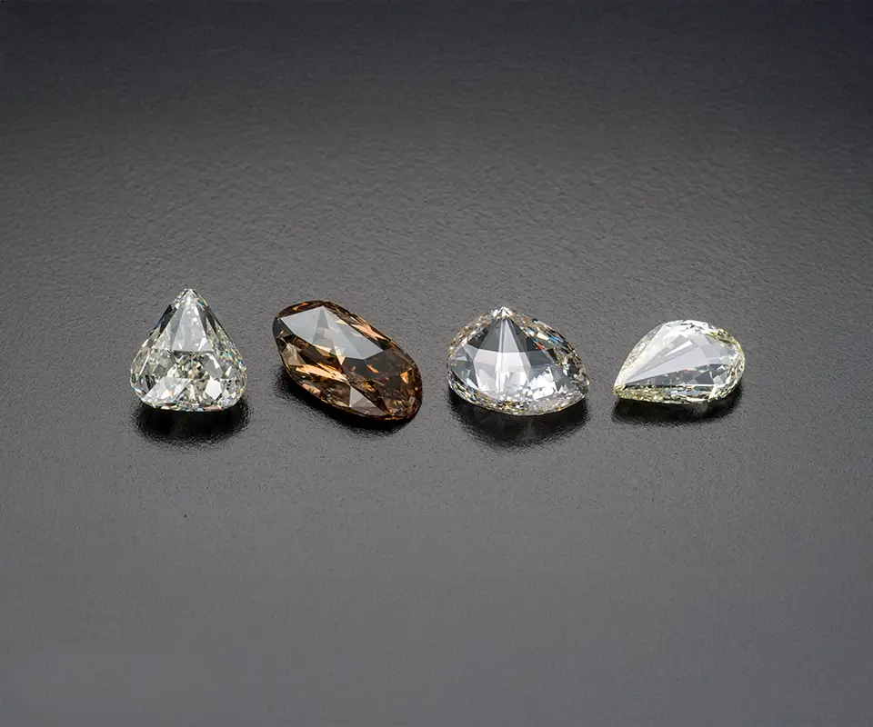 Four seashell cut diamonds ranging from pale yellow to brown