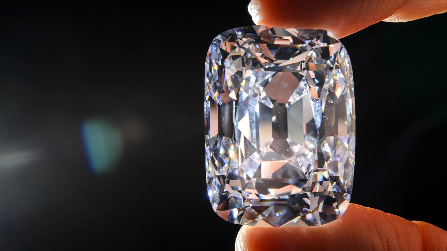 A hand holding the D color, antique cushion cut Archduke Joseph diamond