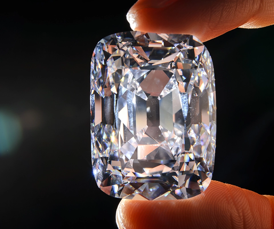 A hand holding the D color, antique cushion cut Archduke Joseph diamond