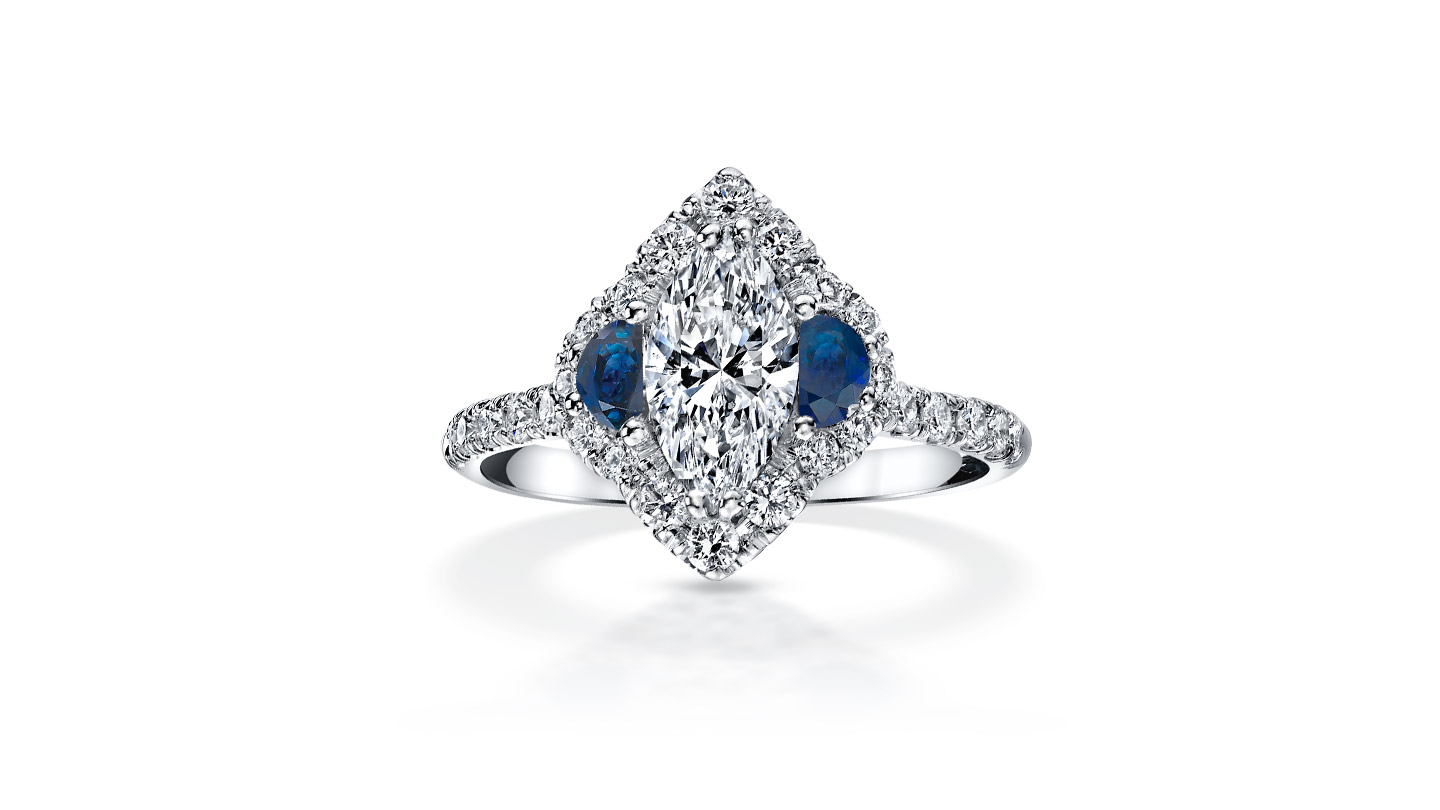 Marquise diamond ring with moon-cut sapphires and diamond pavé halo.